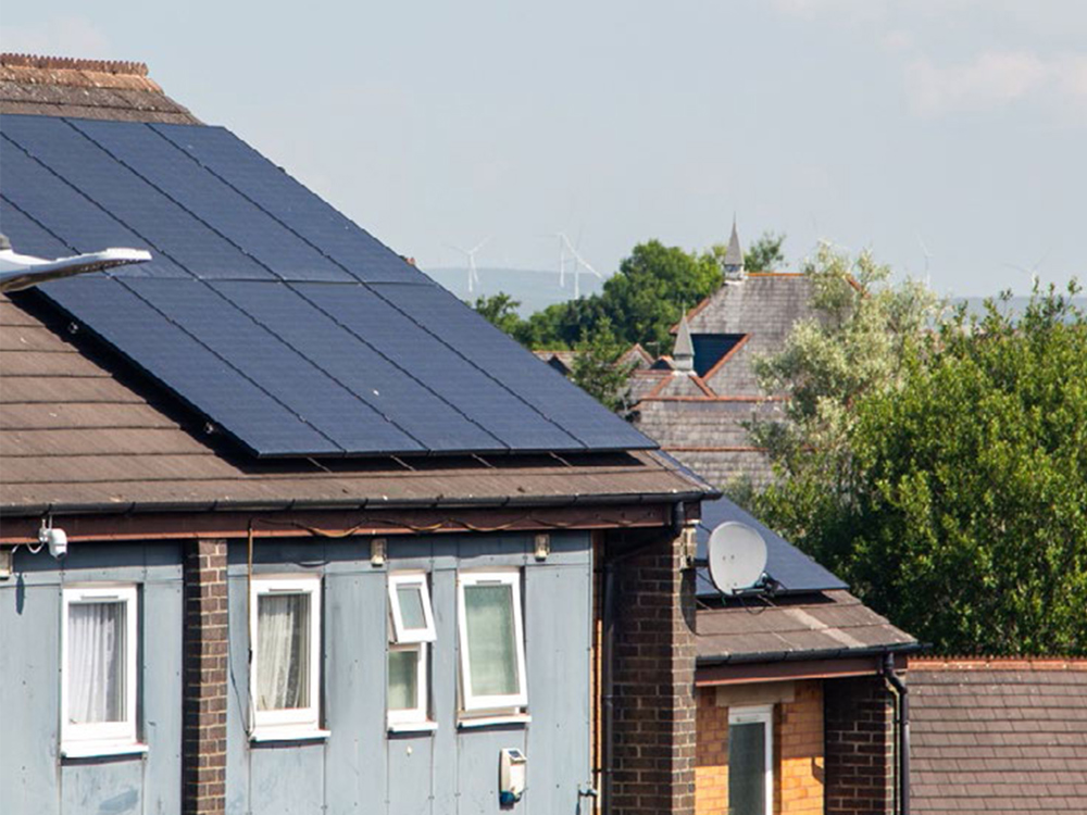 Solar panels on a house with a view of windfarm