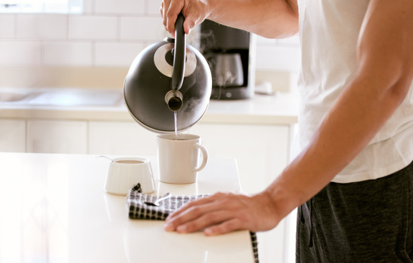 Man Pouring Water Into Cup Tea