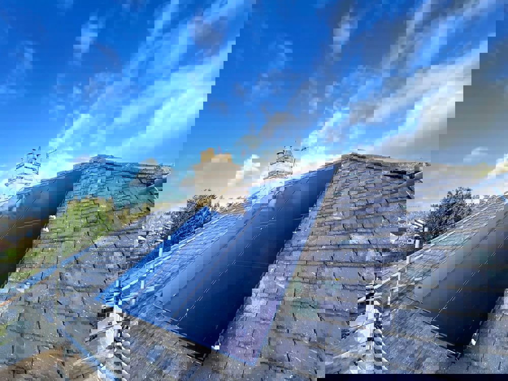 Solar panels on roof with chimney and nice blue skies