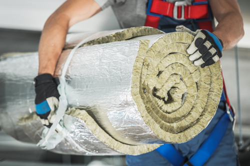 Man holding roll of wool insulation